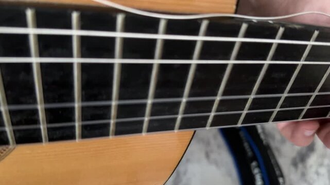 Close up of acoustic guitar body with metal grid background, music instrument detail, abstract composition with texture and shallow depth of field