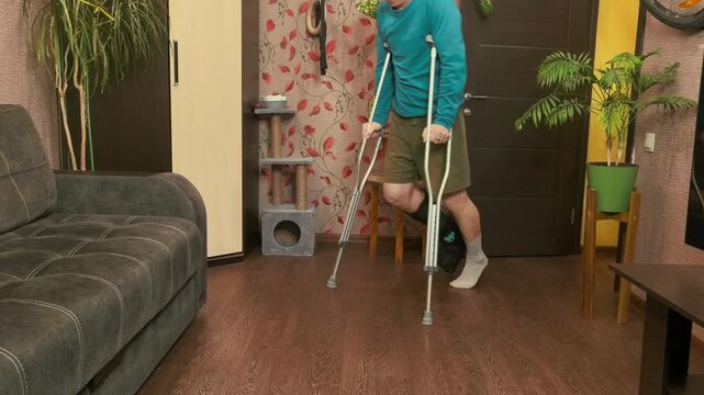Man walking with crutches near sofa at home, rehabilitation movement, recovery and mobility support concept.