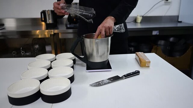 Pastry chef preparing cheesecake bases with biscuits in the kitchen