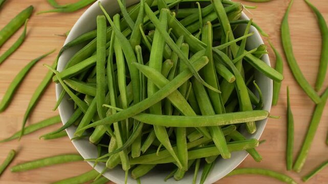 Fresh cluster beans in white bowl top view. Cyamopsis tetragonoloba.