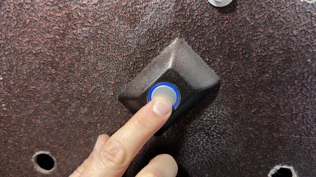 Person pressing door opening button on intercom panel close up outdoors, unlocking entrance door, access control action, security technology use
