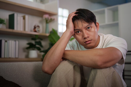 Asian man suffering from depression and anxiety looking at camera