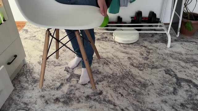 man moving chair across room at home, furniture repositioning, interior arrangement, daily routine, real people