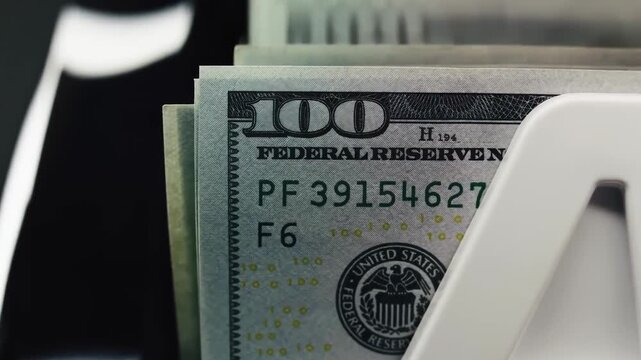 Close Up Money Counting Machine Processing US Dollar Bills in Modern Financial Office