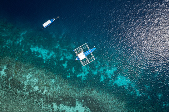 Aerial Top View of Bangka Boats as sand beach by a crystal clear water. Entalula island, Bacuit Bay, El Nido, Palawan, Philippines.