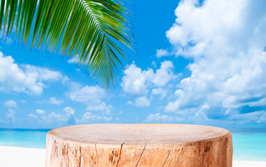 Aged wooden stump pedestal for product display on blurred tropical sea sand beach, sky and green palm leaf background © didecs