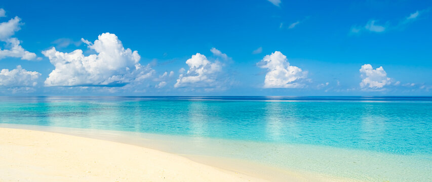 Panoramic view on tropical sea landscape with beautiful white beach sand and turquoise sea water reflecting clouds