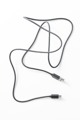 Obraz premium Black USB cable on white backdrop, tangled and disorganized