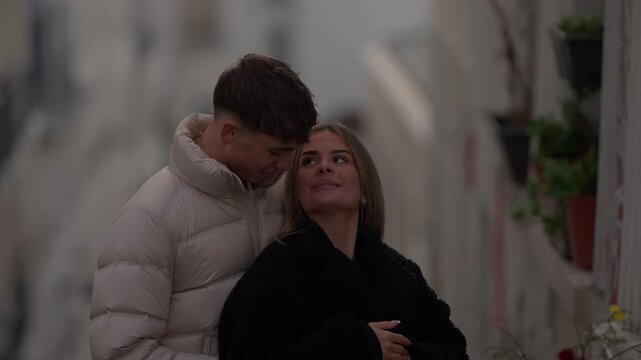 A romantic couple embraces on a street in Paris France The man and woman are in love hugging and sharing an intimate moment The shot is handheld and in slow motion.