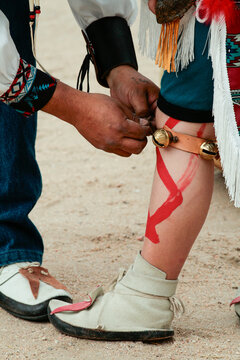 Fastening ankle bells before traditional pueblo dance