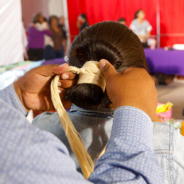 Father helping daughter with traditional Navajo hair wrap