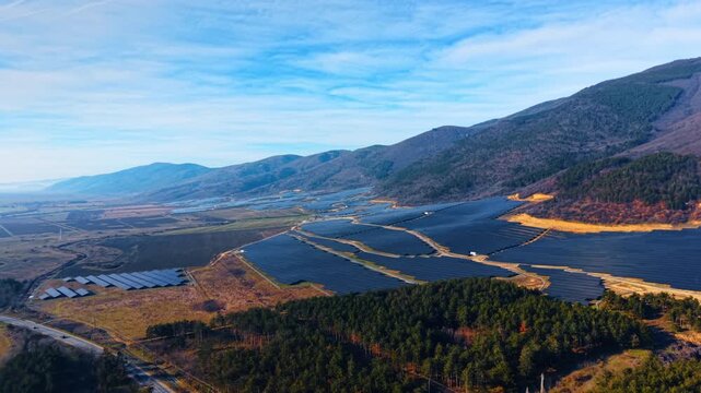 Beautiful mountainous landscape against overcast sky at daytime. Slopes of the rocks are covered with solar panels. Aerial view.