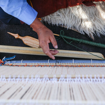 Hand adjusting warp threads on a traditional Navajo loom