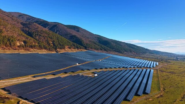 Approaching the solar panel field at the mountain foot. Sunna energy is accumulated by numerous photovoltaic cells.