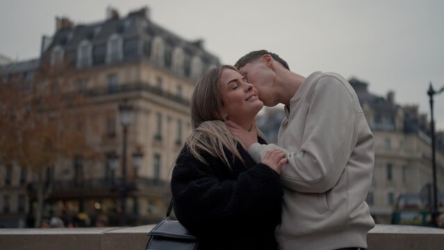 A romantic couple is kissing in Paris France with a cityscape in the background showcasing love and affection. This image is suitable for travel and tourism European vacations and relationship goals.