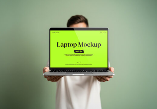 A man holding a laptop in front of him for a mockup