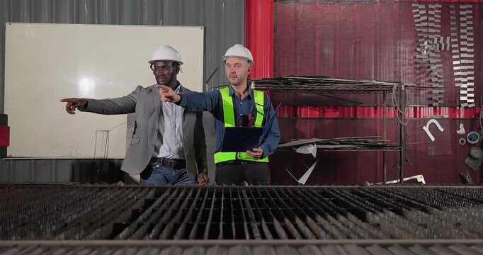 Sales engineer meets a client in an industrial workshop, reviewing quotation details, discussing costs and capabilities, and negotiating terms for a custom production project.
