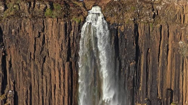 Stunning aerial view descending alongside the powerful mealt falls as it plunges from the basalt columns of kilt rock into the ocean below