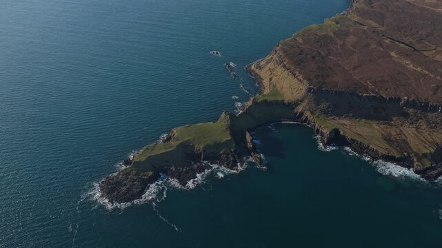 Stunning aerial footage showing the dramatic cliffs of kilt rock and mealt falls pouring into the atlantic ocean on the isle of skye, scotland