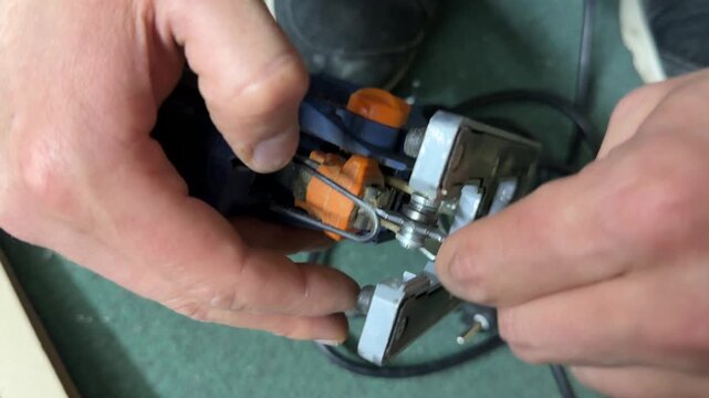 Hands installing blade attachment on electric jigsaw tool, preparation for repair work, construction equipment setup, DIY maintenance concept