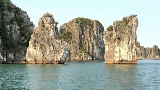 Limestone karst islands rising from calm waters in Halong Bay, Vietnam, serene tropical seascape