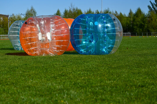 Bunch of bumberballs on a field ready to play zorb soccer.