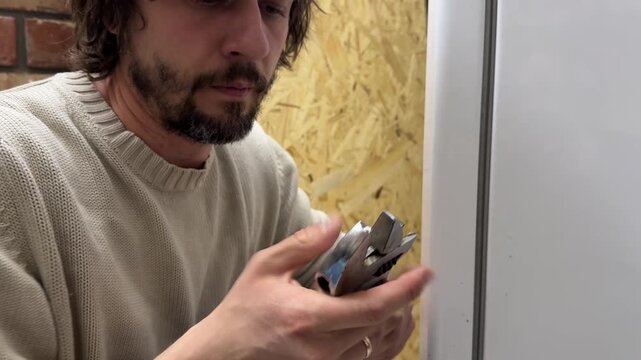 Man adjusting size of adjustable wrench, setting tool opening for correct fit, preparation for repair or mechanical work indoors