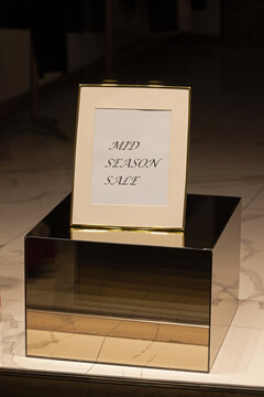 Mid Season Sale Sign in Photo Frame at Mirror Box Shopping Retail Store