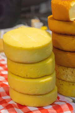 Stacked Wheels of Artisinal Raw Milk Yellow Cheese at Farmers Market Dairy Stall