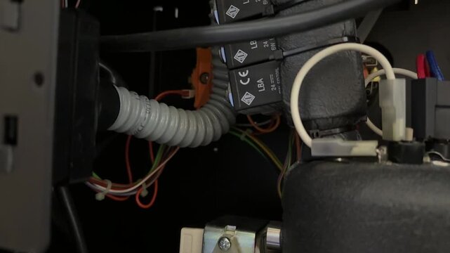 internal compressor and wiring inside appliance in close up, technical cooling system equipment detail