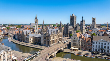 Obraz premium Panoramic aerial view of the historic city center of Ghent, Belgium, with canals and medieval architecture under a clear blue sky.