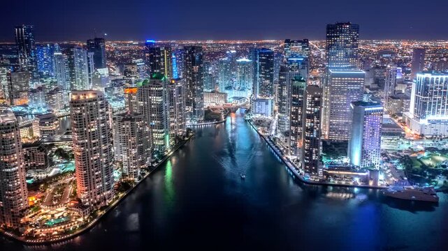 Aerial view of Miami downtown skyline at night. Panoramic drone shot of illuminated skyscrapers, modern buildings and Miami river in Florida, business and luxury travel concep