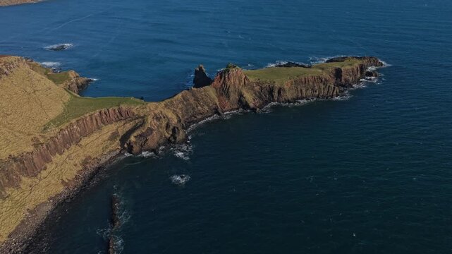 Beautiful aerial view flying backwards, revealing the stunning coastline of brother's point on the isle of skye in the scottish highlands