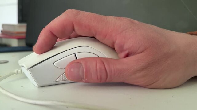 Hand using white computer mouse close up on desk, office technology and productivity concept