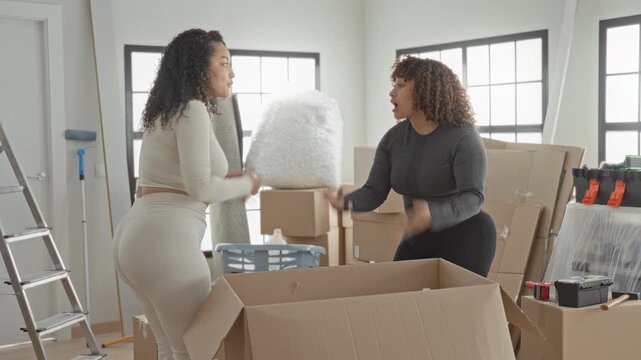 Woman handing a cardboard box with hands visible while two pack and argue in a building; disagreement tension stress.