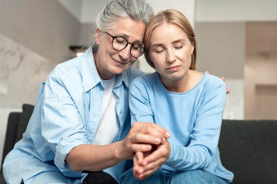Senior woman comforts upset adult daughter at home