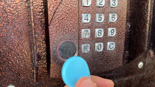 Person pressing intercom keypad button close up outdoors, entering code, access control system, security technology concept