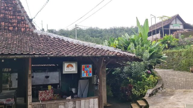Malang, Indonesia - 3 May, 2026: Traditional Javanese Limasan House in Lush Tropical Garden Indonesia