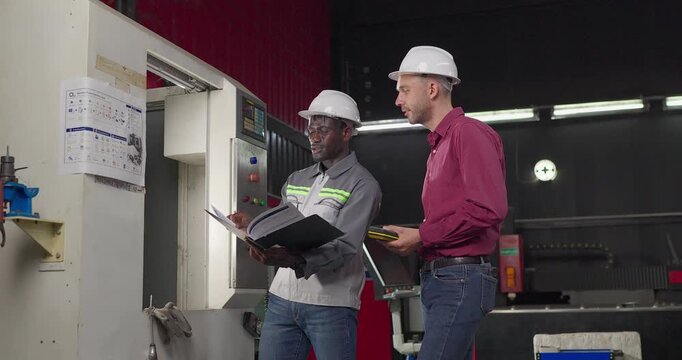 Sales engineer meets a client in an industrial workshop, reviewing quotation details, discussing costs and capabilities, and negotiating terms for a custom production project.
