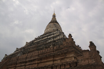 Fototapeta premium Low angle view of an ancient Buddhist pagoda against cloudy sky in Bagan, Myanmar.