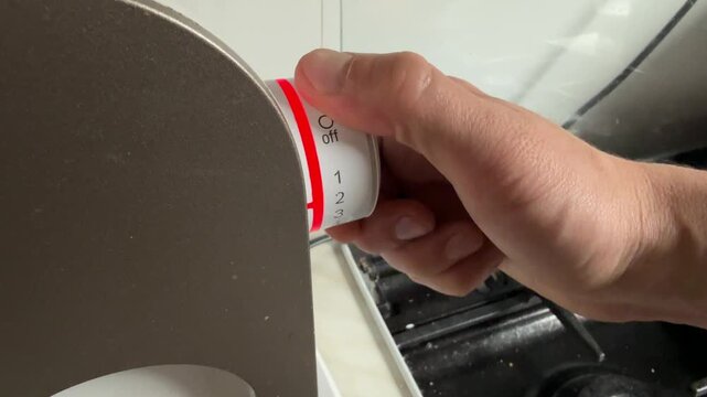 Hand turning illuminated control dial on appliance, modern home electronics setting adjustment concept