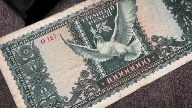 Close up video of a dove emblem with spread wings on a vintage Hungarian Tizmillio Pengo banknote.