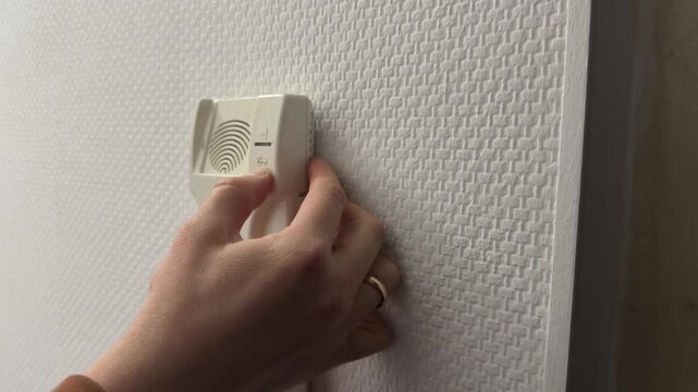 Finger pressing door unlock button on home intercom panel, apartment access control and security concept