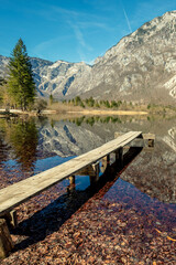 Fototapeta premium Mountain lake with reflection. Wooden boat pier on the lake