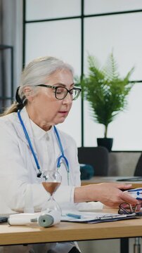 Female doctor wich checking senior adult patient measuring oxygen level during healthycare visit at clinic. Attending physician examines old man hypertension sufferer. Slow motion