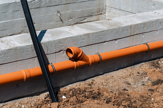 Foundation Pipe With Joint Attachment. Close Examination Of Drainage Joint And Protective Sleeve. Detailed View Highlighting Connection And Sleeve Of Drainage Piping System