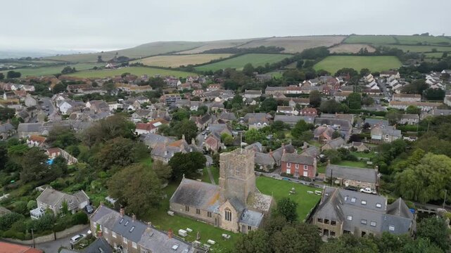 High Aerial View of Burton Bradstock Village with Church and Dorset Coastline England UK