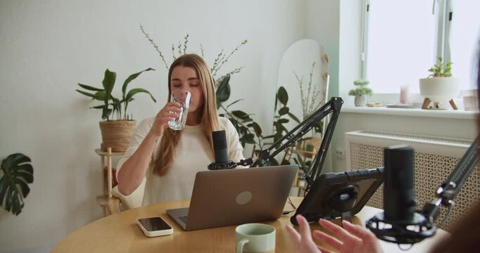 Young female podcaster interviewing a guest in a home studio