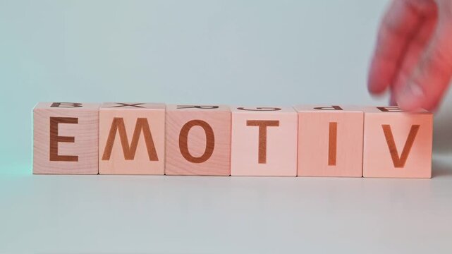 A hand is seen manipulating wooden blocks to form different words focusing on letter arrangement. Changing the word MOTIVE to EMOTION