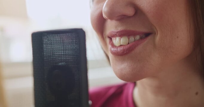 Beautiful woman singing into a professional studio microphone